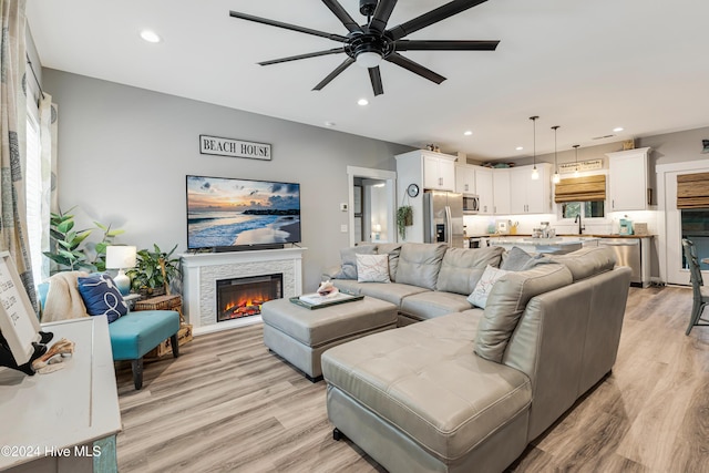 living room with ceiling fan, light hardwood / wood-style floors, and a healthy amount of sunlight