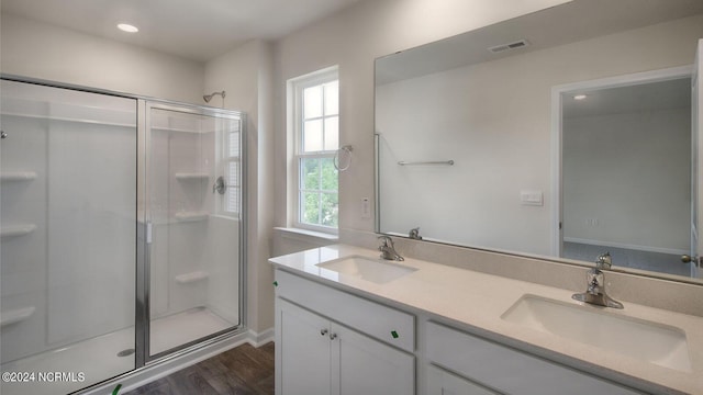 bathroom featuring hardwood / wood-style floors, vanity, and a shower with door