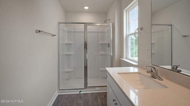 bathroom featuring wood-type flooring, vanity, and an enclosed shower