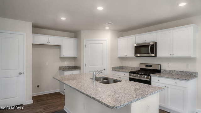 kitchen with sink, white cabinetry, stainless steel appliances, and a kitchen island with sink