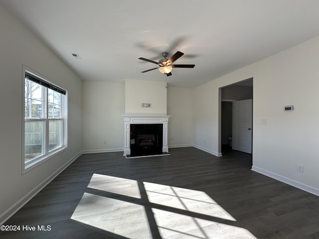 unfurnished living room with ceiling fan and dark wood-type flooring