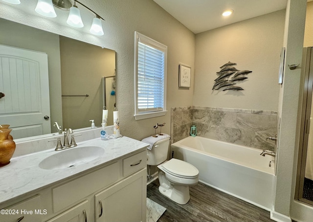 bathroom featuring vanity, hardwood / wood-style flooring, toilet, and a bathing tub