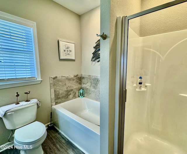 bathroom featuring hardwood / wood-style flooring, toilet, and shower with separate bathtub