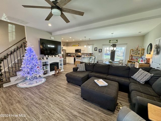 living room with hardwood / wood-style flooring and ceiling fan with notable chandelier