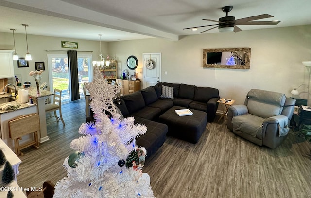 living room featuring beamed ceiling, ceiling fan with notable chandelier, dark wood-type flooring, and sink