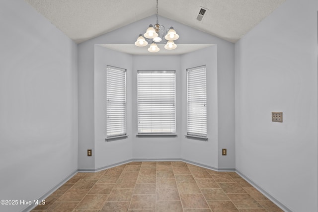 spare room with a chandelier, a textured ceiling, and vaulted ceiling