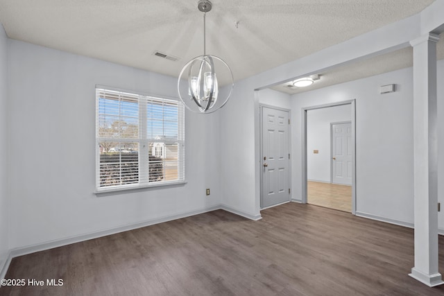 unfurnished dining area with a chandelier, hardwood / wood-style floors, and a textured ceiling