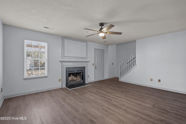 unfurnished living room featuring ceiling fan, a textured ceiling, and hardwood / wood-style flooring