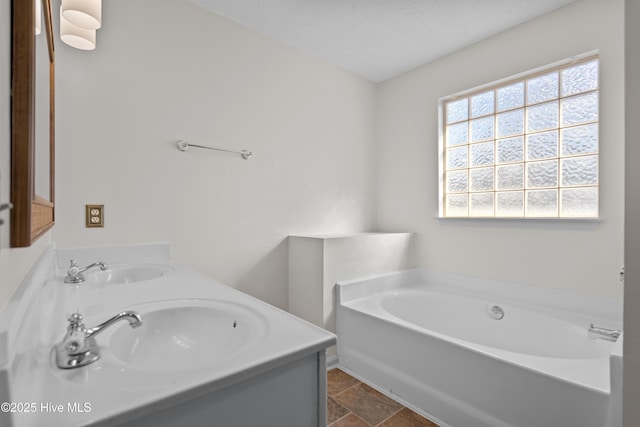 bathroom featuring a bathtub, a textured ceiling, and vanity