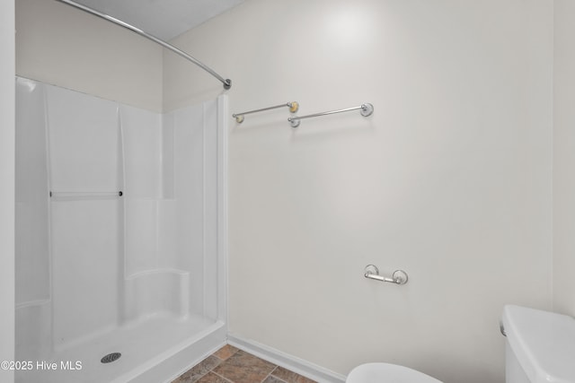 bathroom featuring toilet and walk in shower