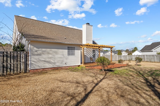 rear view of property featuring a lawn, a pergola, and a wooden deck