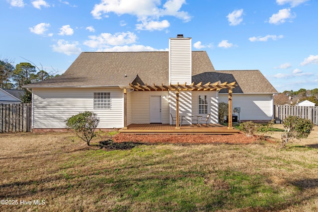 rear view of property with a pergola, a deck, and a lawn