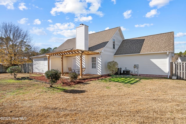 back of property with a yard, a pergola, and central air condition unit