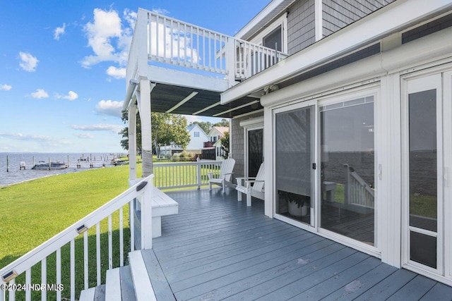 wooden terrace with a lawn and a water view