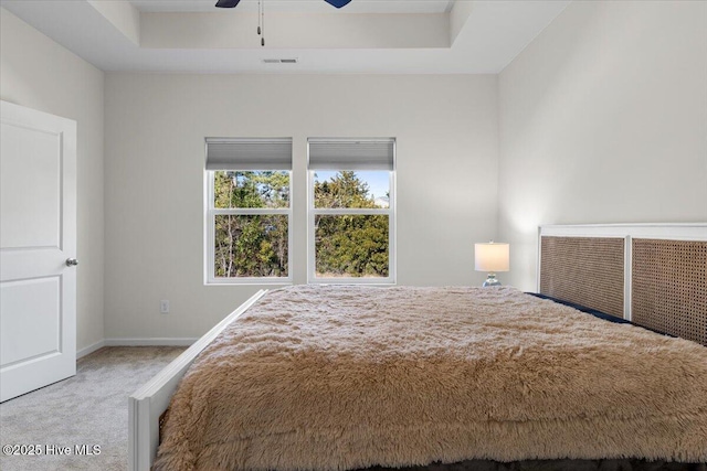 unfurnished bedroom featuring a tray ceiling, ceiling fan, and carpet floors