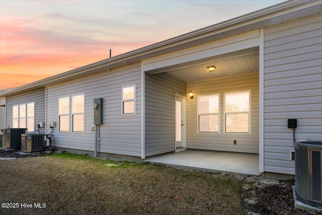 property exterior at dusk featuring a patio area and central AC unit