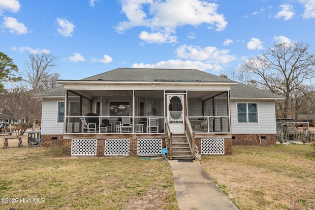 view of front of home featuring crawl space, fence, a front yard, and a sunroom