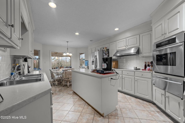 kitchen featuring light tile patterned floors, a kitchen island, a sink, stainless steel appliances, and under cabinet range hood