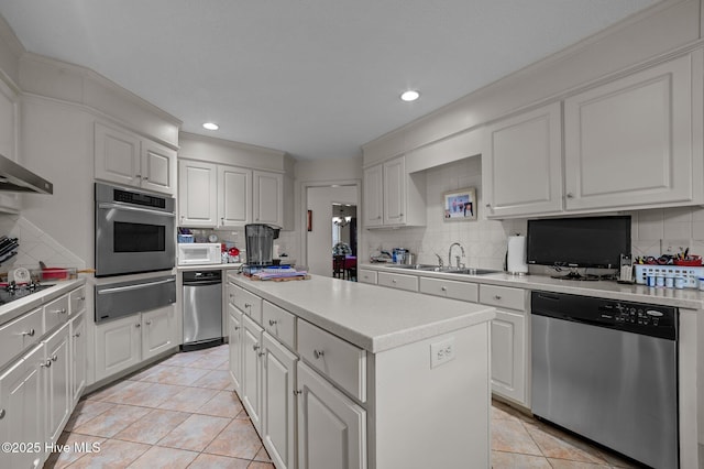 kitchen with a kitchen island, a sink, decorative backsplash, stainless steel appliances, and a warming drawer