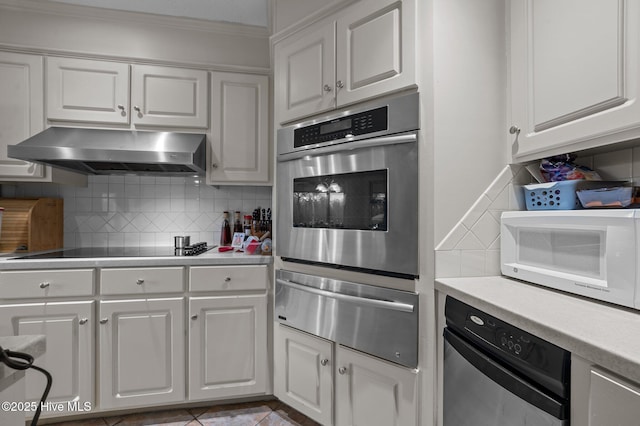 kitchen with black electric stovetop, white cabinets, under cabinet range hood, stainless steel oven, and a warming drawer