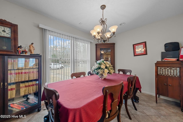 dining area with baseboards, an inviting chandelier, and light tile patterned flooring