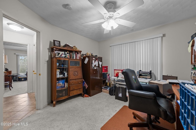 carpeted home office featuring ceiling fan and tile patterned flooring