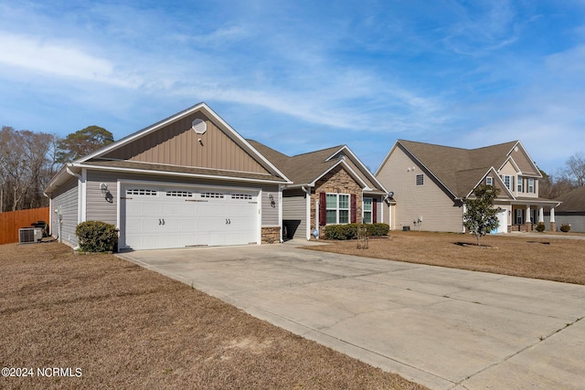 view of front of home featuring a garage, a front yard, and central AC