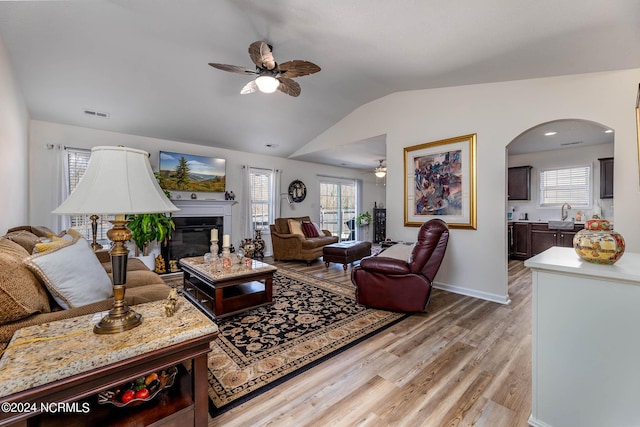 living room featuring ceiling fan, sink, light hardwood / wood-style floors, and lofted ceiling