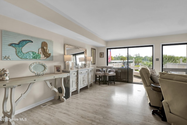 office featuring baseboards, light wood finished floors, and visible vents