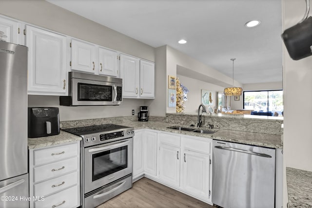 kitchen featuring a sink, appliances with stainless steel finishes, white cabinets, and light wood finished floors