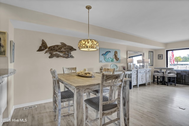 dining room featuring baseboards, visible vents, and light wood-style flooring