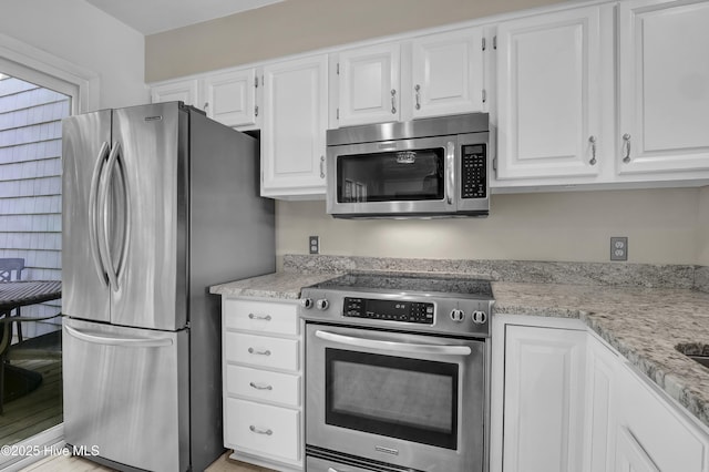 kitchen featuring light stone countertops, white cabinetry, and stainless steel appliances