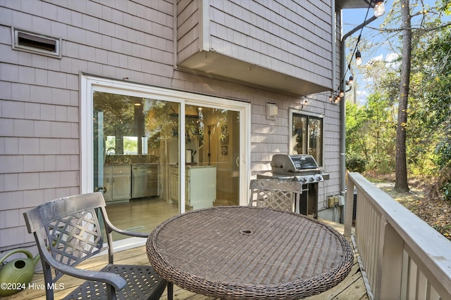 wooden deck with outdoor dining space and area for grilling