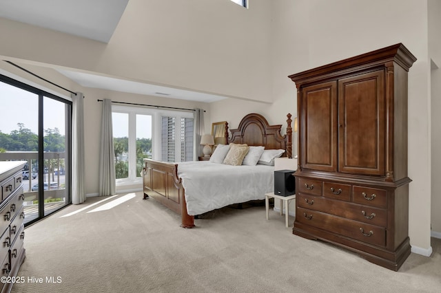 bedroom featuring light colored carpet, baseboards, access to outside, and multiple windows