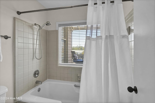 bathroom featuring toilet and shower / bath combo with shower curtain