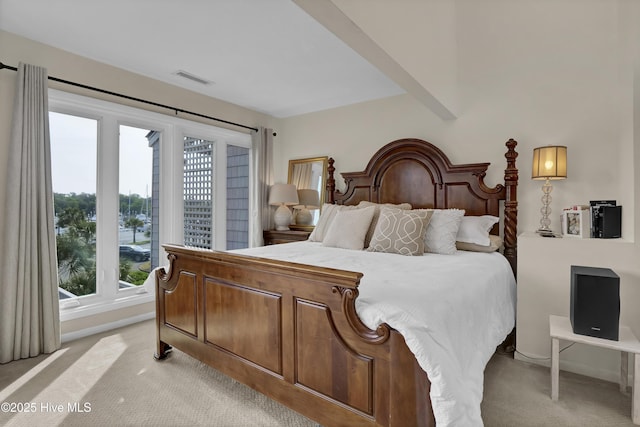 bedroom with baseboards, visible vents, light colored carpet, and multiple windows