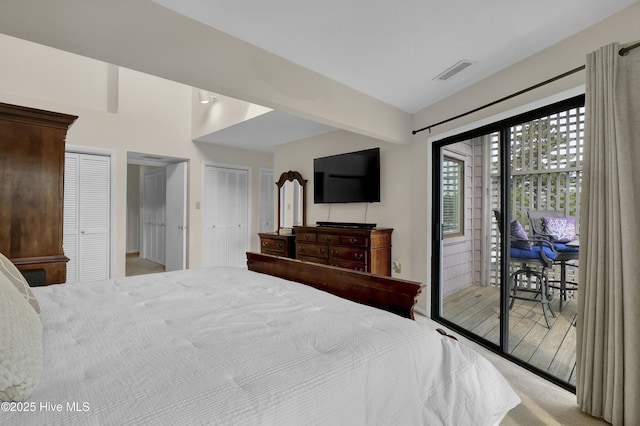 bedroom with visible vents, two closets, and access to exterior
