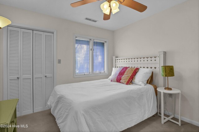 bedroom with visible vents, a closet, carpet floors, baseboards, and ceiling fan