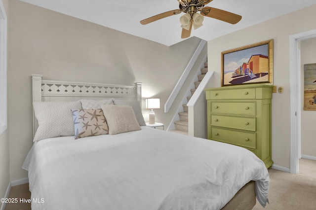bedroom featuring light colored carpet, ceiling fan, and baseboards