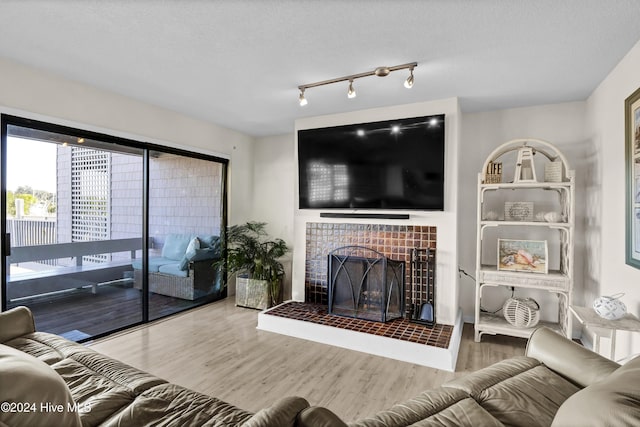 living area with wood finished floors and a tiled fireplace