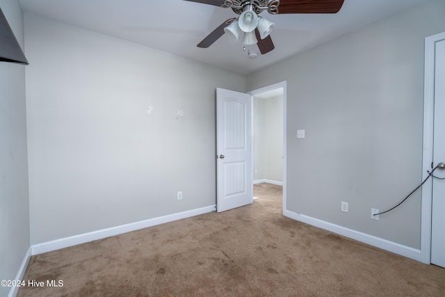 spare room with light colored carpet and ceiling fan