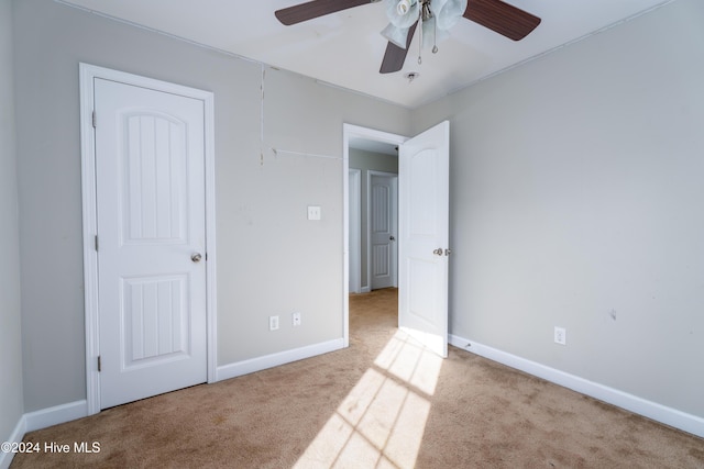 unfurnished bedroom with light colored carpet and ceiling fan