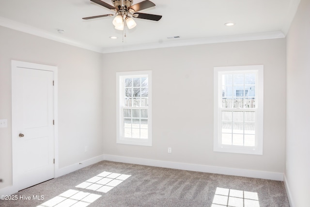 carpeted spare room with a wealth of natural light, ornamental molding, and ceiling fan