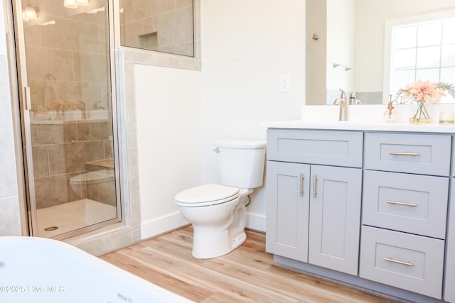 bathroom featuring hardwood / wood-style floors, vanity, toilet, and an enclosed shower