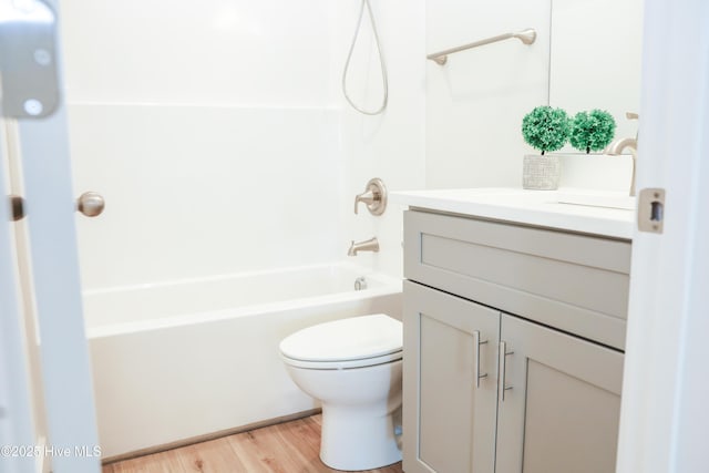 full bathroom featuring hardwood / wood-style floors, vanity, toilet, and shower / bathing tub combination