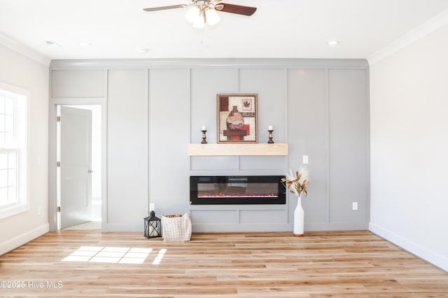 living room featuring light hardwood / wood-style floors, ceiling fan, and ornamental molding