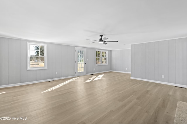 unfurnished room featuring light hardwood / wood-style floors, a wealth of natural light, crown molding, and ceiling fan