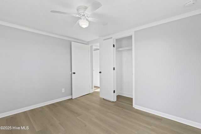 unfurnished bedroom with a closet, ceiling fan, crown molding, and light wood-type flooring