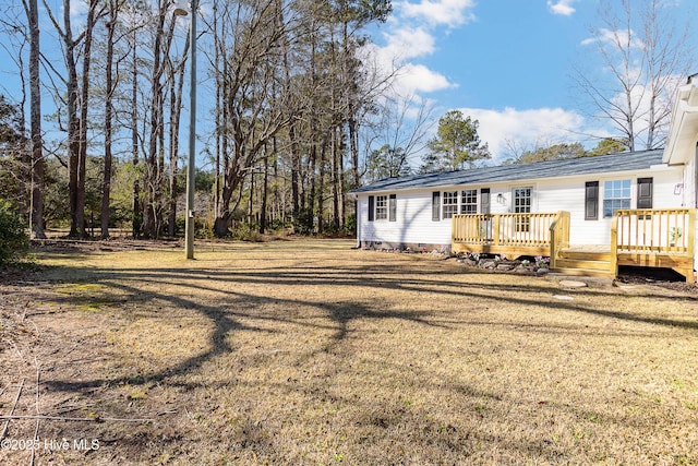 rear view of property with a lawn and a deck