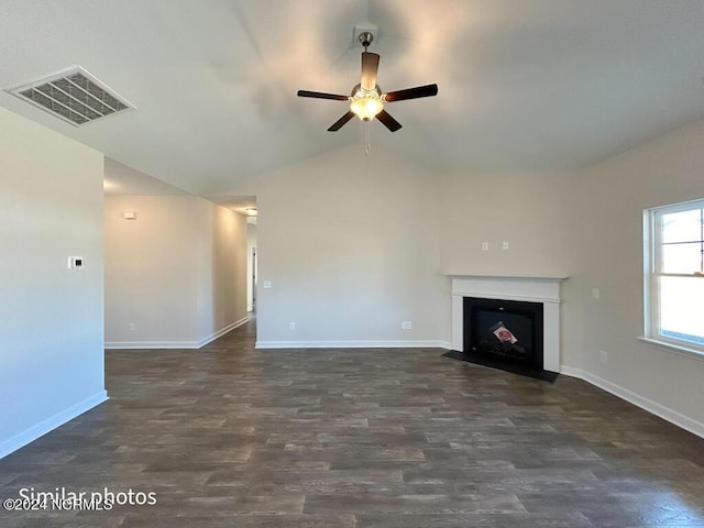 unfurnished living room featuring dark hardwood / wood-style flooring, vaulted ceiling, and ceiling fan